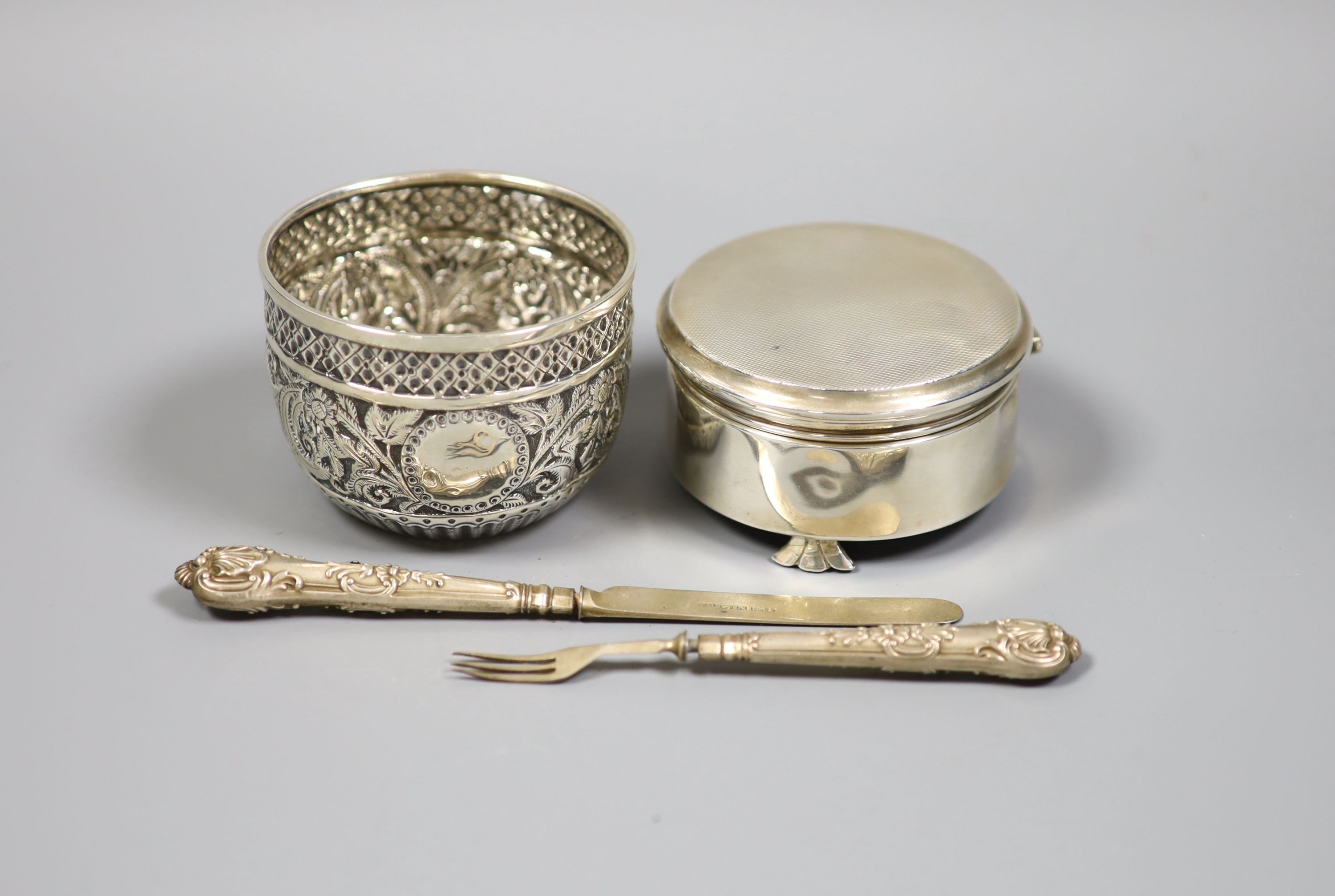 A late Victorian repousse silver bowl, London, 1898, diameter 8cm, a modern silver mounted circular trinket box, Birmingham, 1976 and a christening knife and fork, the knife with silver blade.